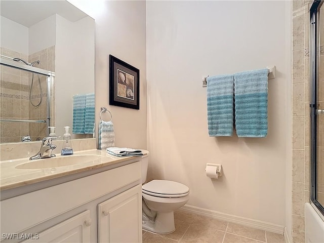 bathroom with baseboards, toilet, vanity, and tile patterned flooring