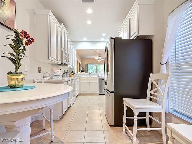 kitchen with light countertops, light tile patterned floors, recessed lighting, stainless steel appliances, and a sink