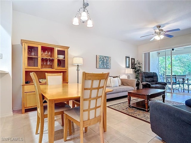 dining space featuring light tile patterned floors and ceiling fan with notable chandelier