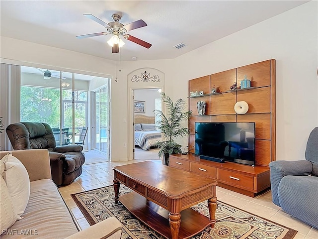 living room with light tile patterned flooring, visible vents, a sunroom, and ceiling fan