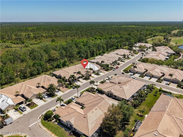drone / aerial view featuring a residential view and a view of trees