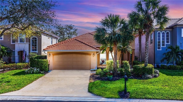 view of front of house with driveway, a tile roof, a front yard, and stucco siding