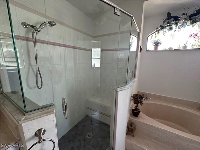 full bathroom with a garden tub and a shower stall