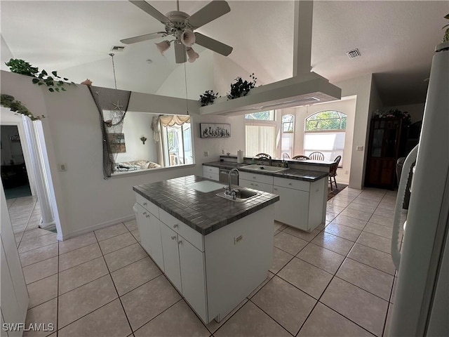 kitchen featuring a kitchen island with sink, white cabinets, and a sink