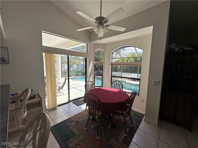 dining space with lofted ceiling, a healthy amount of sunlight, ceiling fan, and light tile patterned flooring