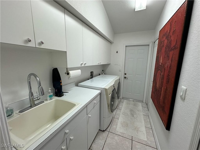 laundry room with cabinet space, light tile patterned floors, a sink, and washing machine and clothes dryer