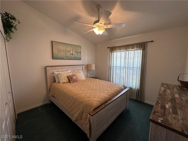 bedroom with lofted ceiling, dark colored carpet, ceiling fan, and baseboards