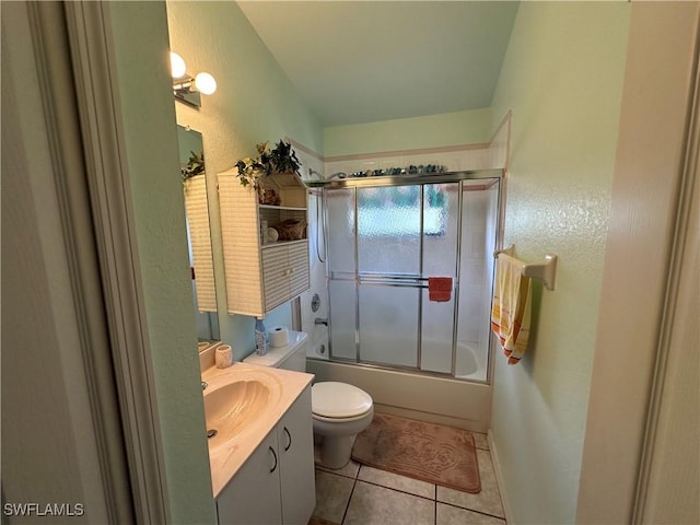 full bath featuring toilet, enclosed tub / shower combo, vanity, baseboards, and tile patterned floors