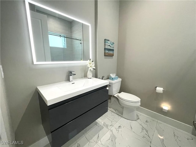 bathroom with toilet, vanity, baseboards, marble finish floor, and a shower stall