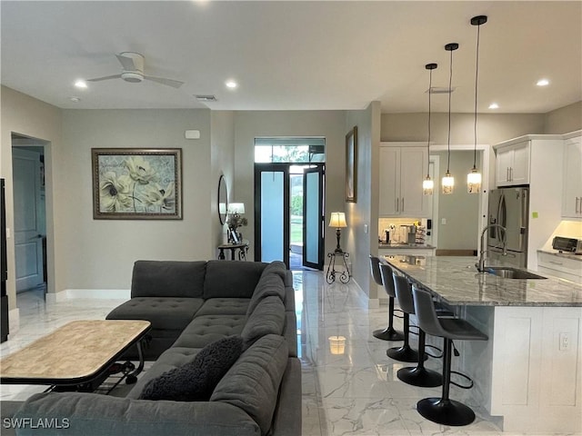 living room featuring marble finish floor, baseboards, visible vents, and recessed lighting