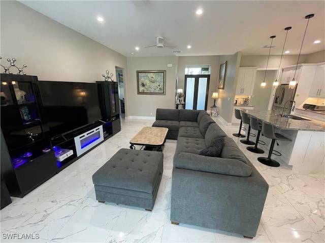 living room featuring marble finish floor, a ceiling fan, and recessed lighting