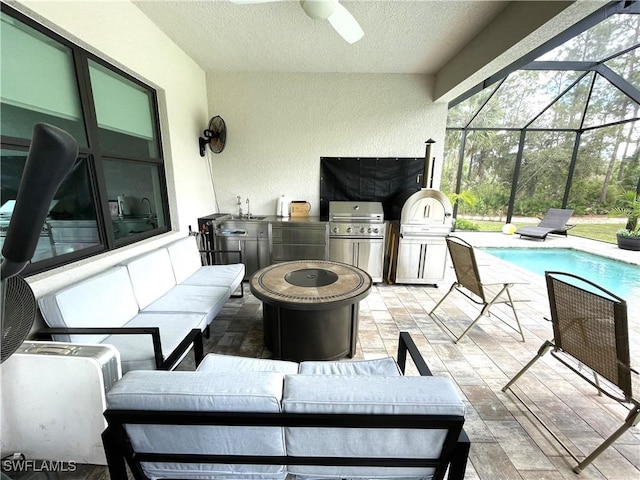 view of patio / terrace with an outdoor hangout area, grilling area, a lanai, exterior kitchen, and a sink