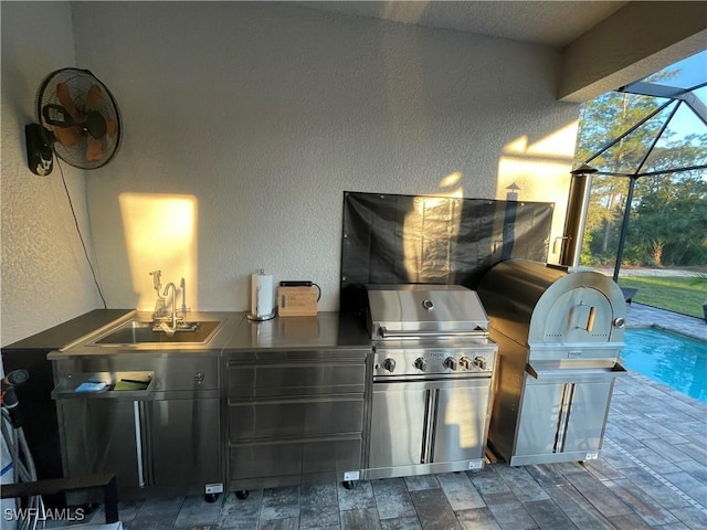 view of patio / terrace with a sink, an outdoor kitchen, area for grilling, and a lanai