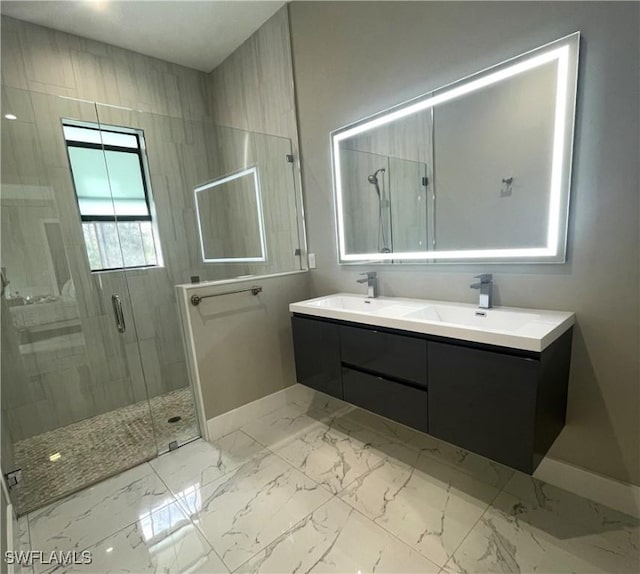 full bath with double vanity, marble finish floor, a shower stall, and a sink