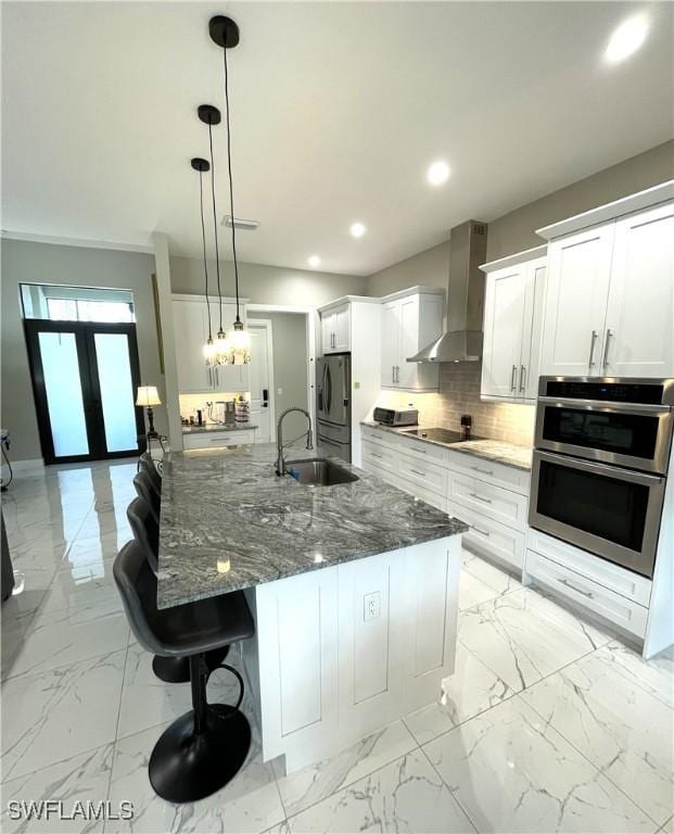 kitchen with marble finish floor, a sink, wall chimney exhaust hood, and french doors