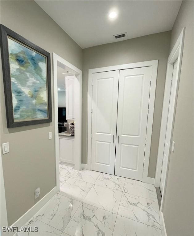 hall featuring marble finish floor, visible vents, and baseboards