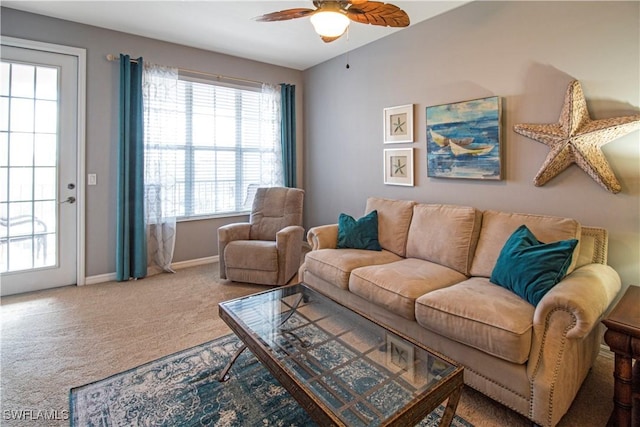 carpeted living room with baseboards and a ceiling fan