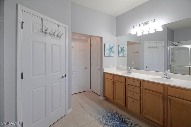 bathroom featuring tile patterned flooring, a sink, a shower stall, and double vanity