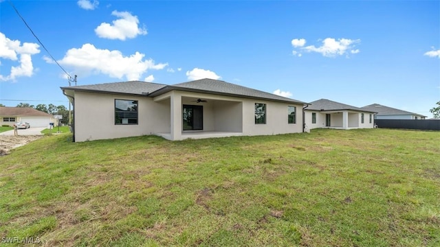 back of house featuring a patio area, stucco siding, and a yard