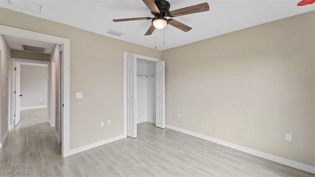 unfurnished bedroom featuring light wood finished floors, a closet, visible vents, a ceiling fan, and baseboards