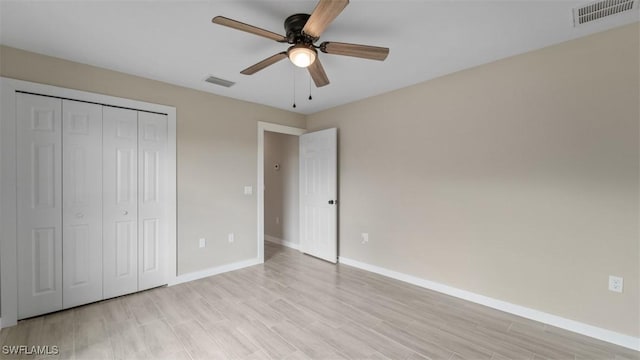 unfurnished bedroom featuring light wood-style floors, a closet, visible vents, and baseboards