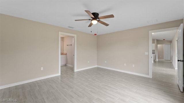 empty room featuring a ceiling fan, light wood-style flooring, and baseboards