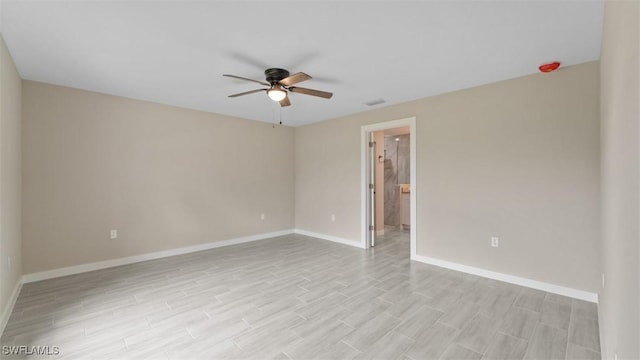 empty room with a ceiling fan, visible vents, light wood-style flooring, and baseboards