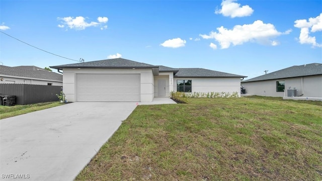 view of front facade featuring concrete driveway, an attached garage, central AC, fence, and a front lawn