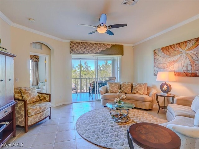 living room featuring light tile patterned floors, a ceiling fan, visible vents, baseboards, and ornamental molding