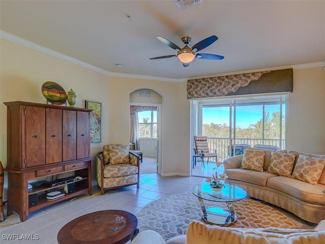 living room featuring ornamental molding, ceiling fan, baseboards, and light tile patterned floors