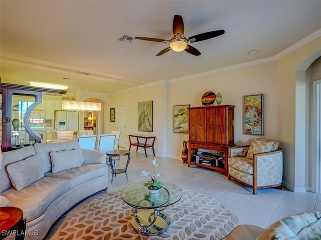 living area with arched walkways, ornamental molding, light tile patterned flooring, and visible vents