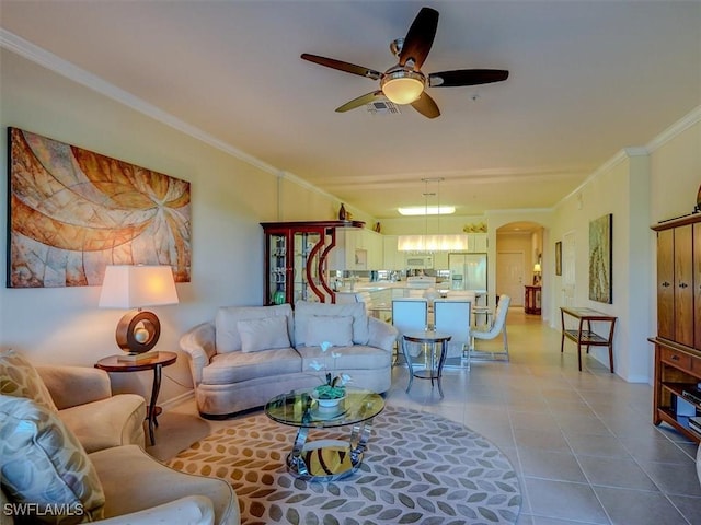 living area with arched walkways, tile patterned flooring, crown molding, and visible vents