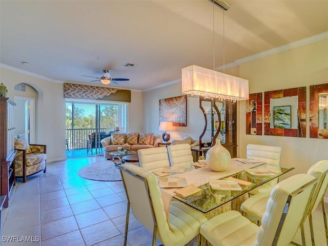 dining room featuring arched walkways, crown molding, visible vents, ceiling fan, and tile patterned floors