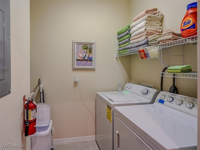 clothes washing area with laundry area, baseboards, separate washer and dryer, and light tile patterned flooring