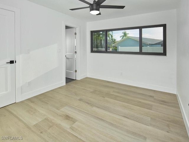 unfurnished room with a ceiling fan, baseboards, and wood finished floors