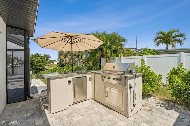 view of patio featuring exterior kitchen, grilling area, and fence