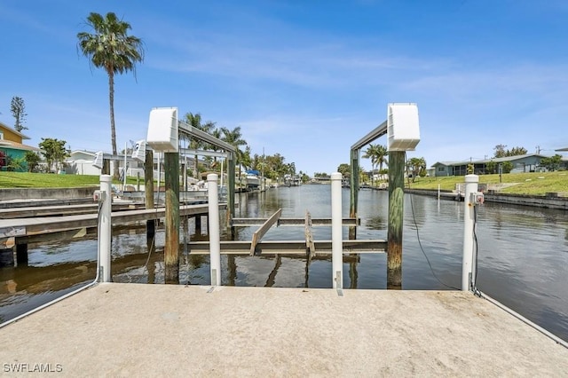 view of dock featuring a water view, boat lift, and a residential view