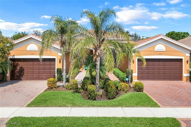 view of front of property with decorative driveway, an attached garage, and stucco siding