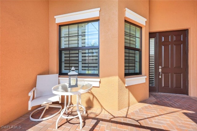 entrance to property featuring a patio area and stucco siding