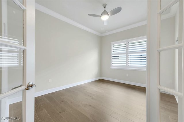 empty room with baseboards, ornamental molding, ceiling fan, and wood finished floors