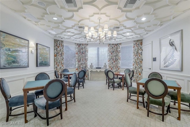 dining room featuring a wainscoted wall, crown molding, visible vents, a decorative wall, and a chandelier