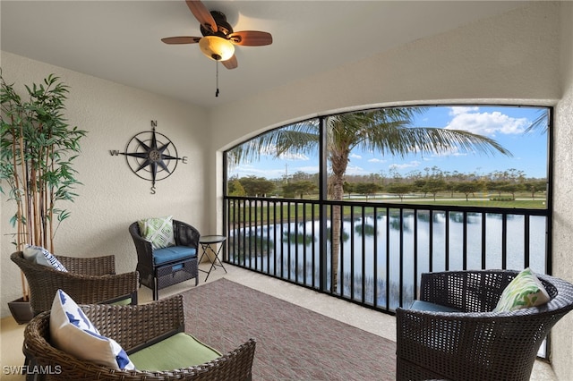 sunroom / solarium with a water view and ceiling fan