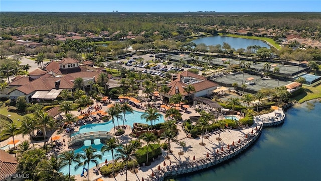 drone / aerial view with a residential view, a water view, and a wooded view