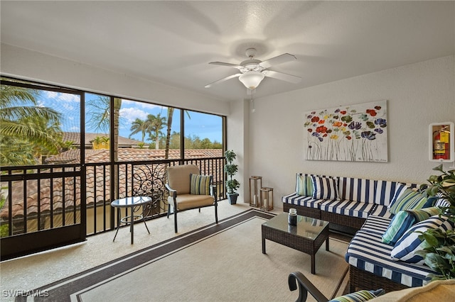 living area featuring carpet floors, ceiling fan, and a textured wall