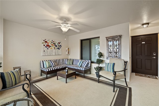 carpeted living area with a ceiling fan