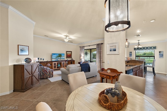 dining area featuring crown molding, tile patterned floors, visible vents, baseboards, and ceiling fan with notable chandelier