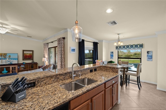 kitchen featuring crown molding, brown cabinets, and a sink