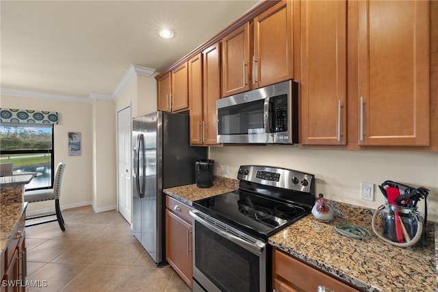 kitchen with stainless steel appliances, ornamental molding, brown cabinetry, and light stone countertops