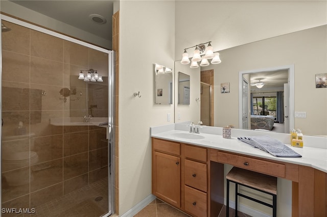 bathroom featuring tile patterned flooring, connected bathroom, vanity, baseboards, and a stall shower