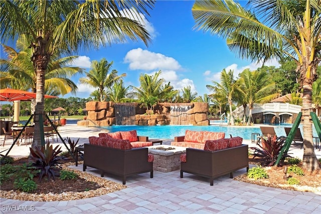 view of swimming pool featuring an outdoor living space with a fire pit and a patio